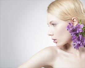 Caucasian woman wearing purple flowers in hair