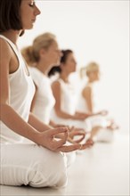 Close up of women meditating in yoga class