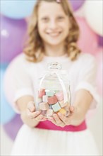 Girl holding glass jar of candy