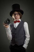 Boy in top hat photographing with vintage camera