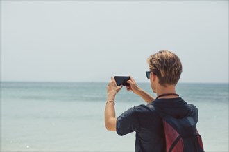 Caucasian man photographing seascape
