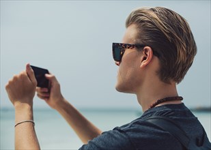 Caucasian man photographing seascape