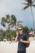 Caucasian man talking on cell phone on beach