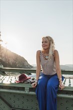 Caucasian woman sitting on bridge
