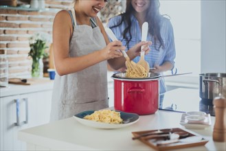 Caucasian women cooking pasta in kitchen