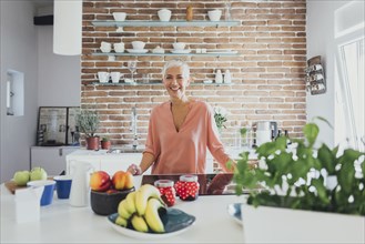 Older Caucasian woman smiling in kitchen