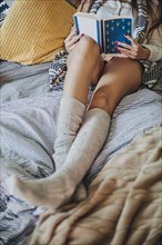Woman reading book on bed