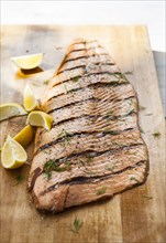 Salmon on cutting board with lemon wedges