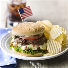Cheeseburger and potato chips with American flag