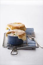 Seafood pot pies and forks on rack
