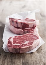 Raw rib eye steaks on butcher paper
