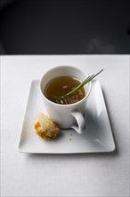 Spring of herb in cup of broth with bread