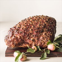 Cooked glazed ham on wooden cutting board