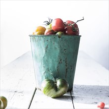 Bucket of fresh tomatoes on wooden table