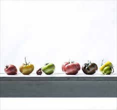 Row of fresh tomatoes on wooden table
