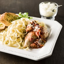 Plate of chicken and pasta with bread