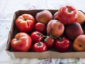 Box of fresh tomatoes and peaches