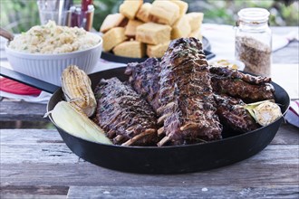 Pan of barbecue ribs on wooden table