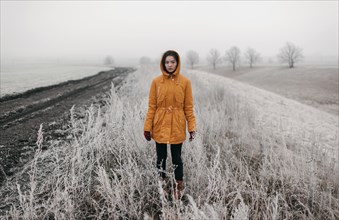 Caucasian woman standing in snowy field