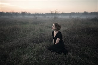 Caucasian woman sitting in remote field