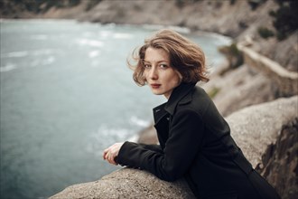 Caucasian woman standing on cliff over coastline