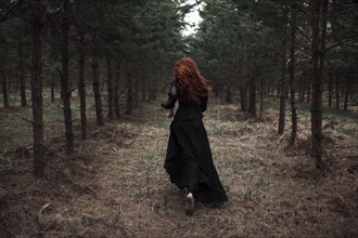 Caucasian woman walking on forest path