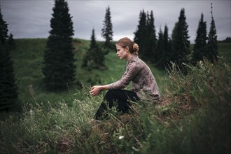 Caucasian woman sitting in remote field