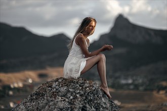 Caucasian woman sitting on remote hilltop