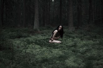 Caucasian woman sitting in forest