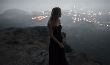 Caucasian woman on hilltop admiring cityscape view