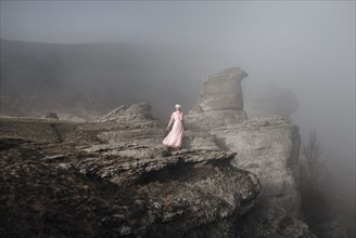 Caucasian woman standing on misty rock formation