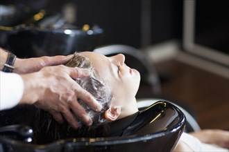 Woman having her hair washed in salon