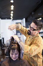 Hairdresser cutting hair in salon