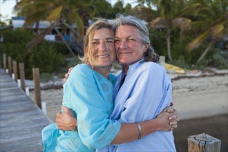 Caucasian mother and daughter hugging on pier