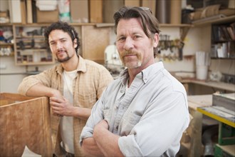 Co-workers woodworking in workshop