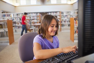 Girl using computer in library