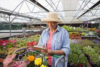 Mixed race woman working in plant nursery
