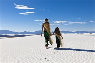 Caucasian mother and daughter walking in desert