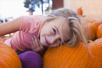 Caucasian girl sitting with pumpkins