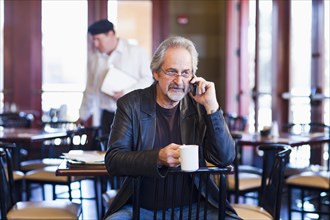 Caucasian man on cell phone in restaurant