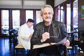 Caucasian man holding menu in restaurant