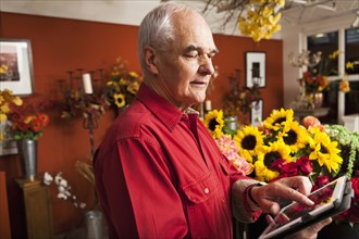 Caucasian florist using tablet computer in shop