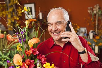 Caucasian florist talking on phone in shop