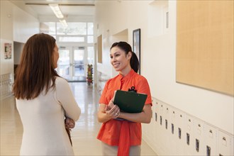 Teachers talking in school hallway