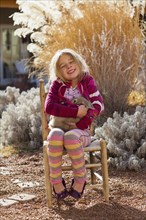 Caucasian girl smiling in chair outdoors