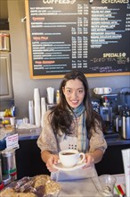 Mixed race woman working in coffee shop