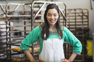 Mixed race woman working in bakery kitchen