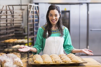 Mixed race woman baking in industrial kitchen