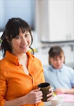 Woman having cup of coffee in kitchen