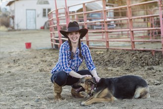 Caucasian girl petting dog on farm